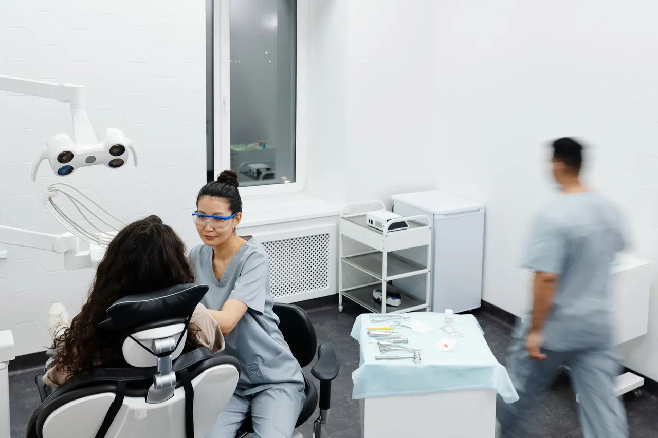 Un dentista che parla con un paziente in una sala visite luminosa
