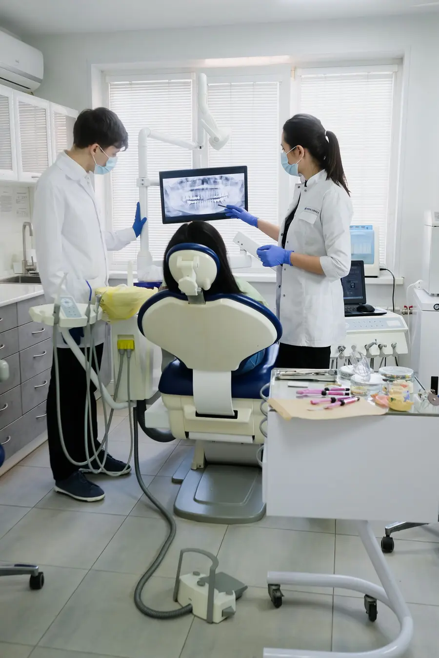 Due membri del team dentale che preparano una sala visite
