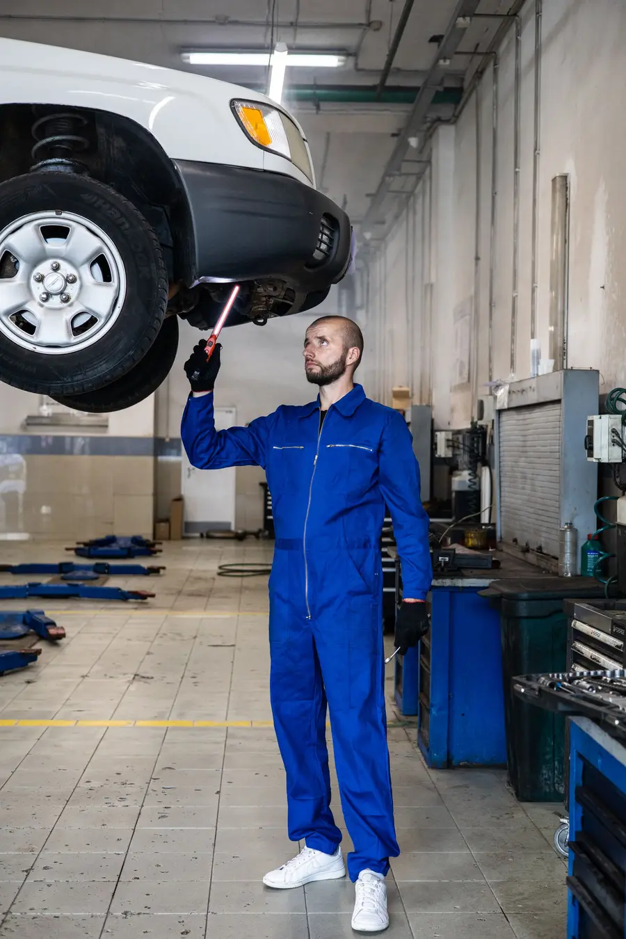 Un meccanico che controlla la parte inferiore di un’auto
