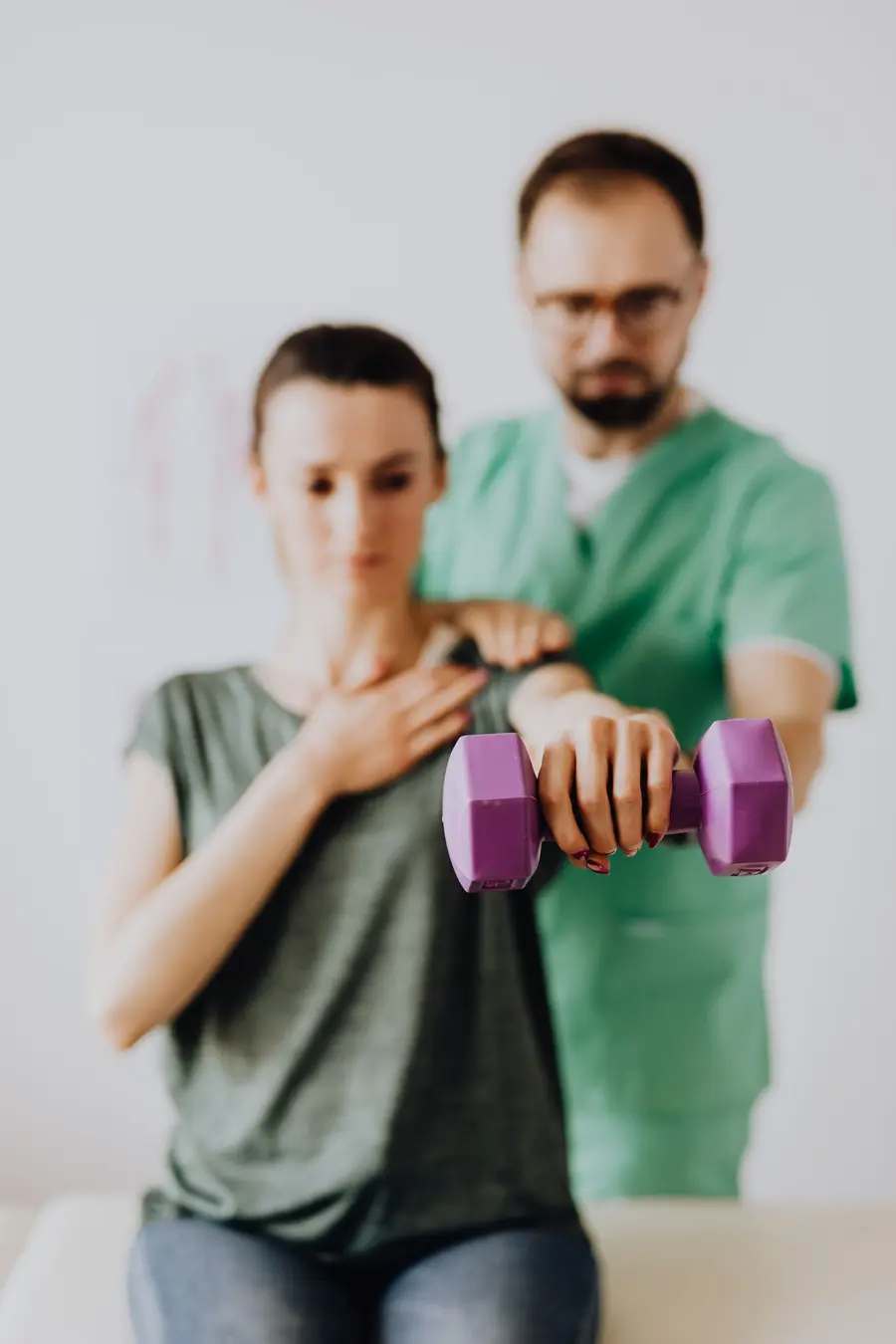 A physiotherapist guiding a patient through a shoulder exercise