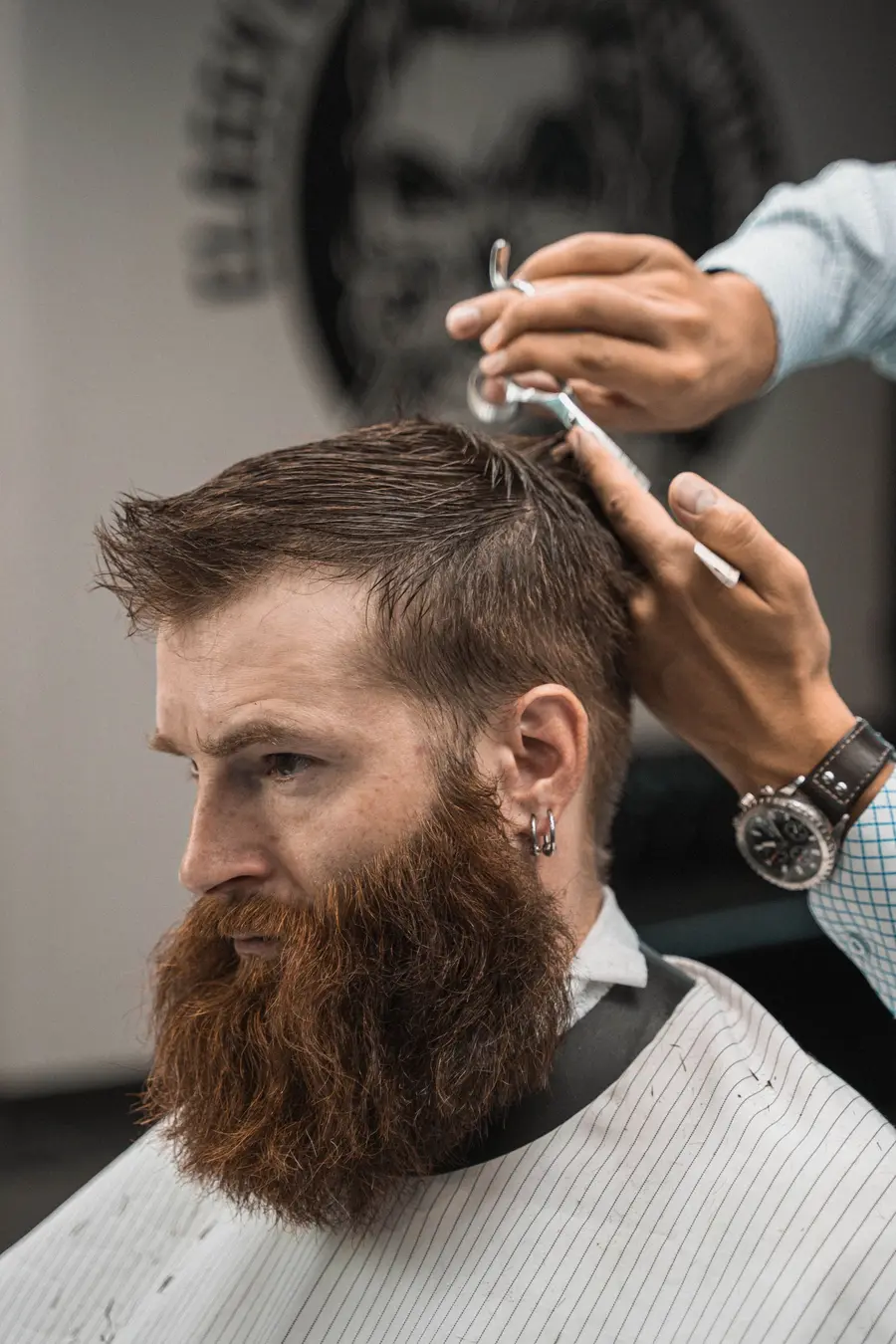 Un barbero arreglando el pelo y la barba a un cliente