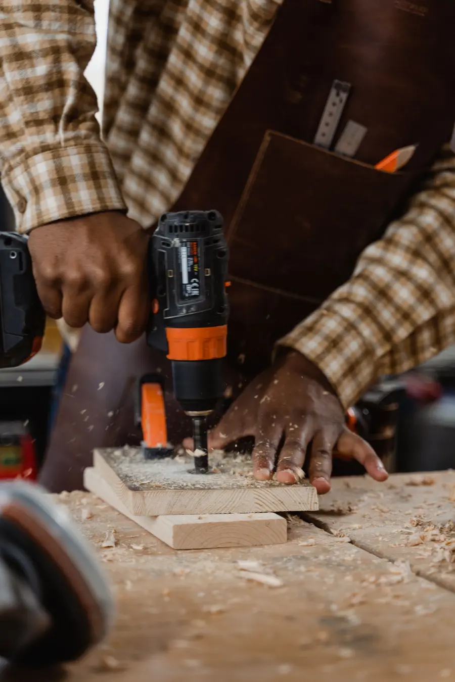 A carpenter drilling into timber
